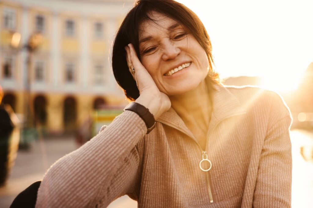 Smiling woman enjoying sunset glow.