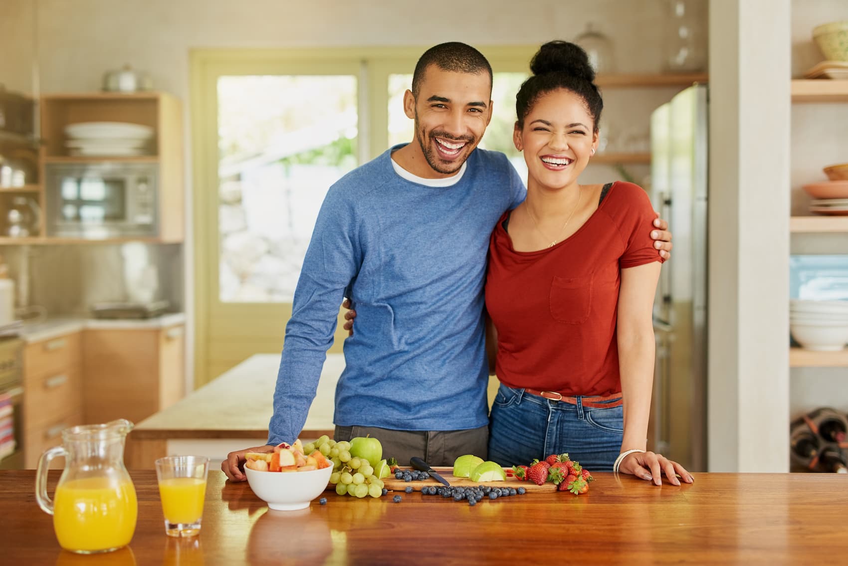 Happy couple in kitchen with fruits