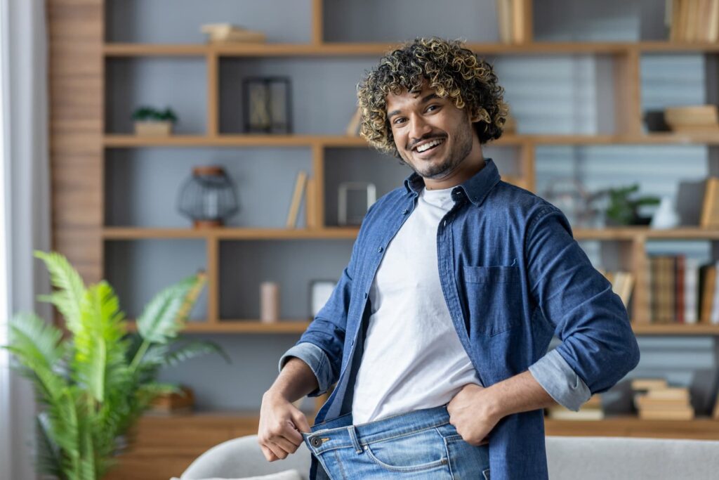 Man smiling while showing oversized pants