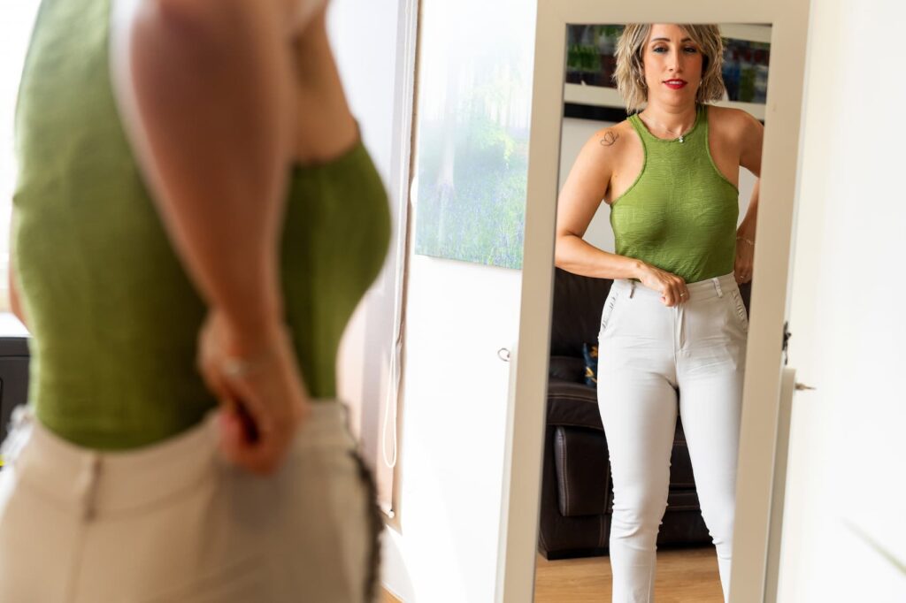 Woman adjusting outfit in mirror
