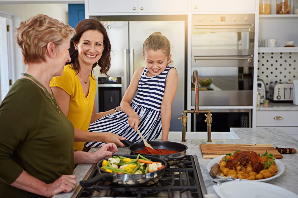 Three women cooking together happily.